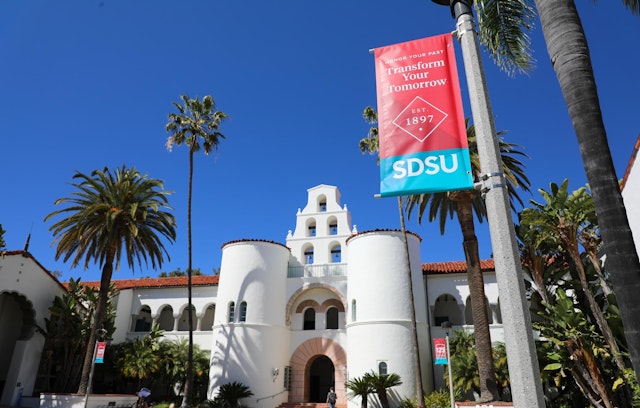 San Diego State University campus during the day with flag that reads, "Transform Your Tomorrow".