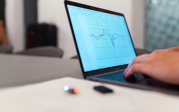 A computer screen displays data while a person types.