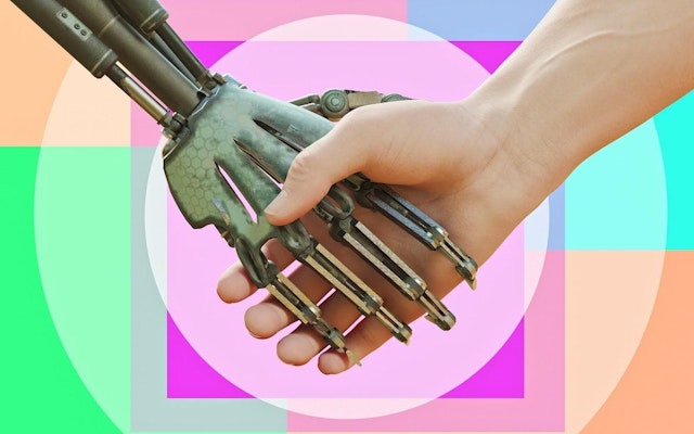 A human hand holding a robot hand against a pastel-colored background.