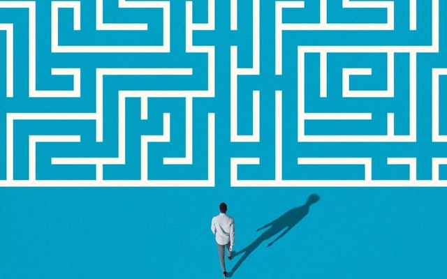 An illustration of a man walking into a maze.