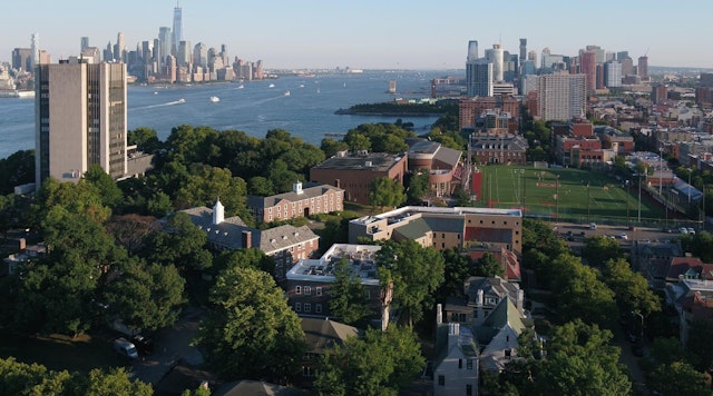 Aerial view of the Stevens campus with the NYC and Jersey City skylines, and DeBaun Athletic Complex.
