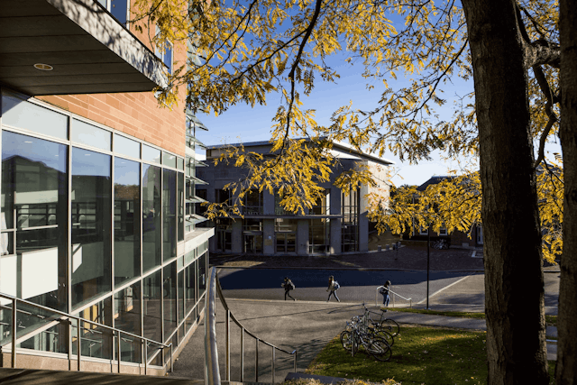 Students walk across campus in autumn.
